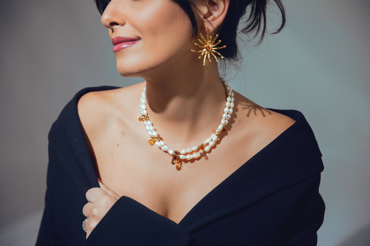 Dunia's Flowers earring worn with a beaded necklace